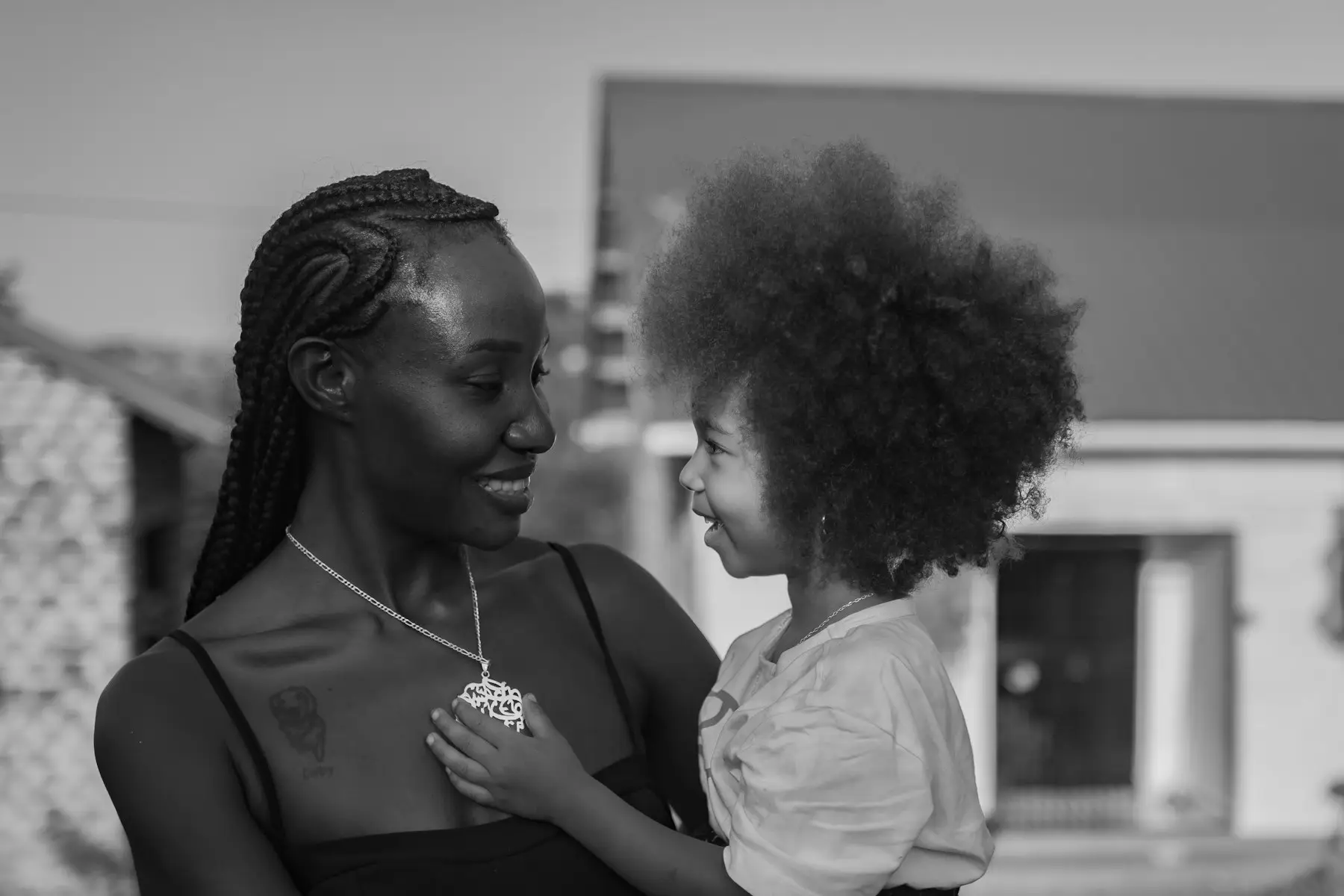 A mother and her young daughter smiling at each other